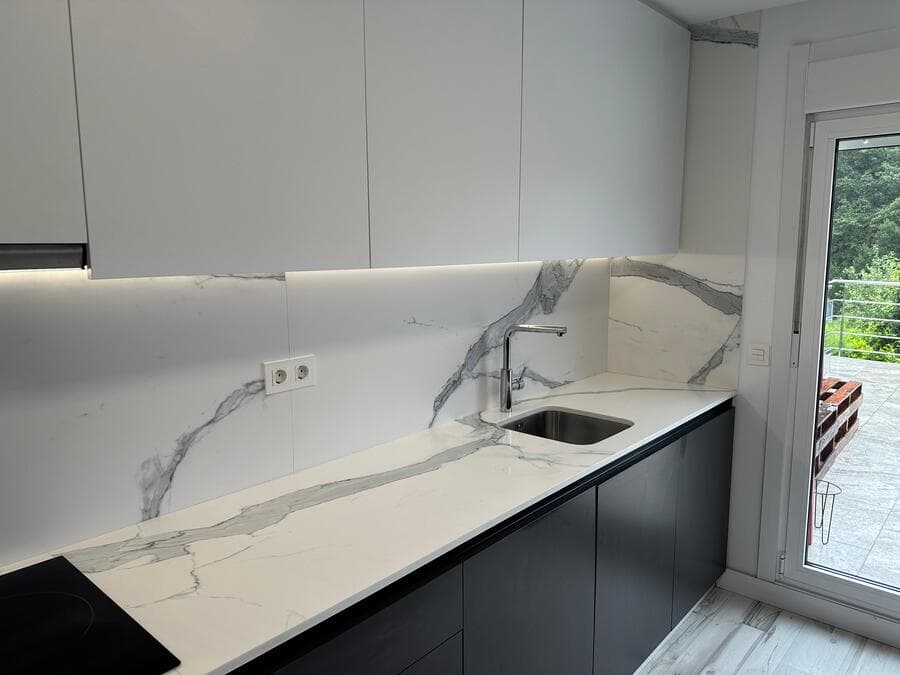 Cocina a medida en Ames con encimera de mármol y muebles bajos en negro mate