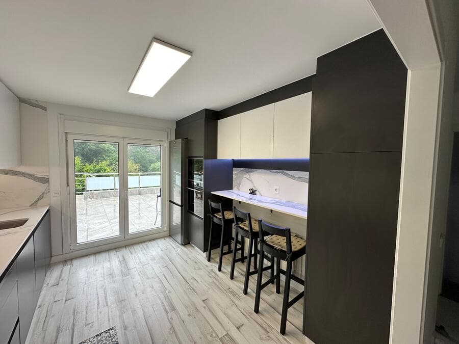 Cocina a medida en Ames con salida a la terraza y península con taburetes