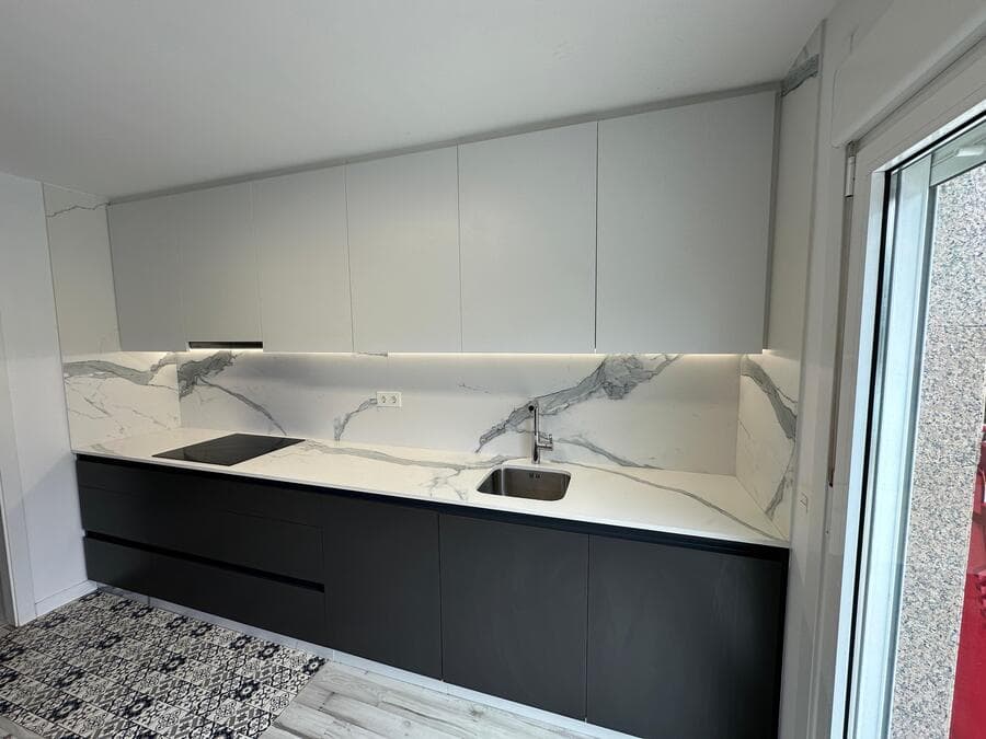Cocina a medida en Ames bajo techo abuhardillado con muebles negros y blancos